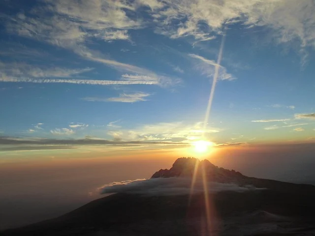 Mount Kilimanjaro rising above the clouds viewed from the summit ridge of Mount Meru at sunrise