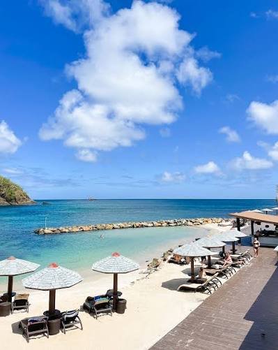 Tranquil uncrowded beach shore under a leafy rock overhang on Chapwani Island Zanzibar