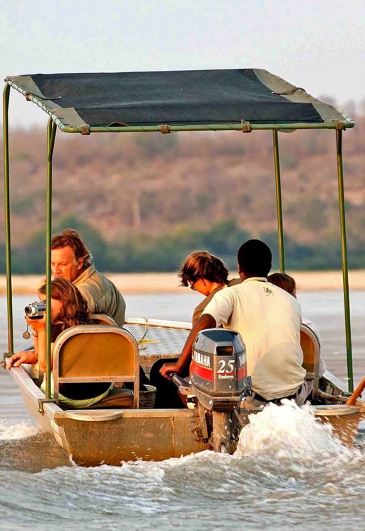 Tourists taking a scenic boat safari ride along the wide waters of the Rufiji River in Selous Tanzania